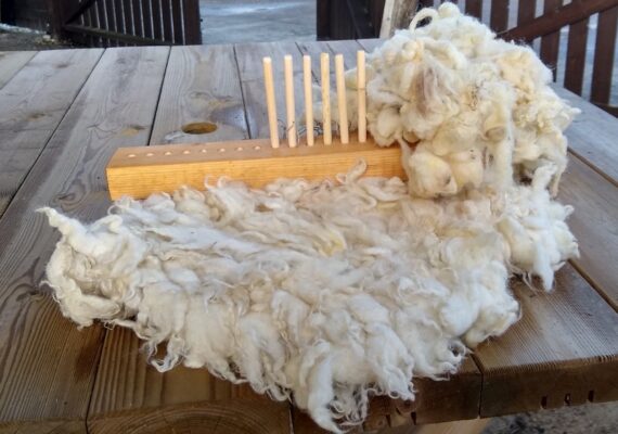 fluffy tuffet and peg loom on a wooden picnic table