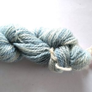hank of blue sock yarn on a graded white to grey background