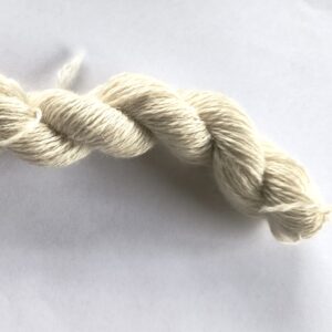 skein of natural cream coloured yarn on a grey/white background