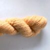 hank of pale orange sock yarn on a graded white to grey background