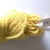 hank of pale yellow sock yarn on a shaded grey to white backgound