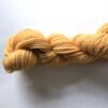 A skein of apricot yarn on a white backgound