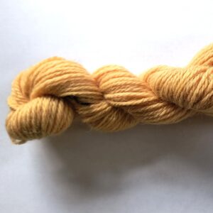 A skein of apricot yarn on a white backgound