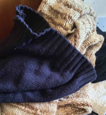 A pile of jumpers muddled up with different colours ready for washing