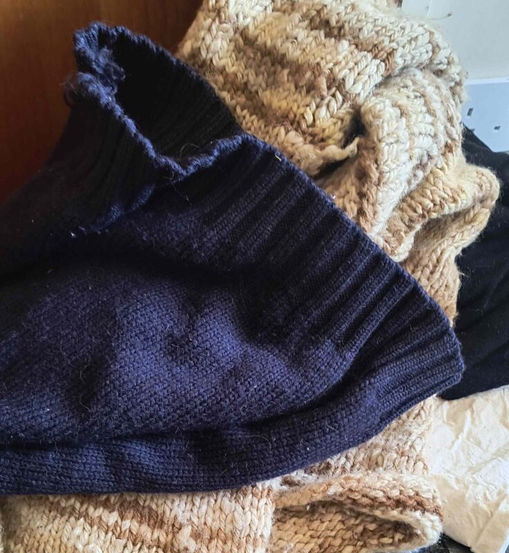 A pile of jumpers muddled up with different colours ready for washing
