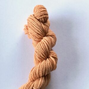 Salmon pink skein of wool on a white background