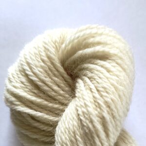 End of the skein of natural cream yarn on a white background